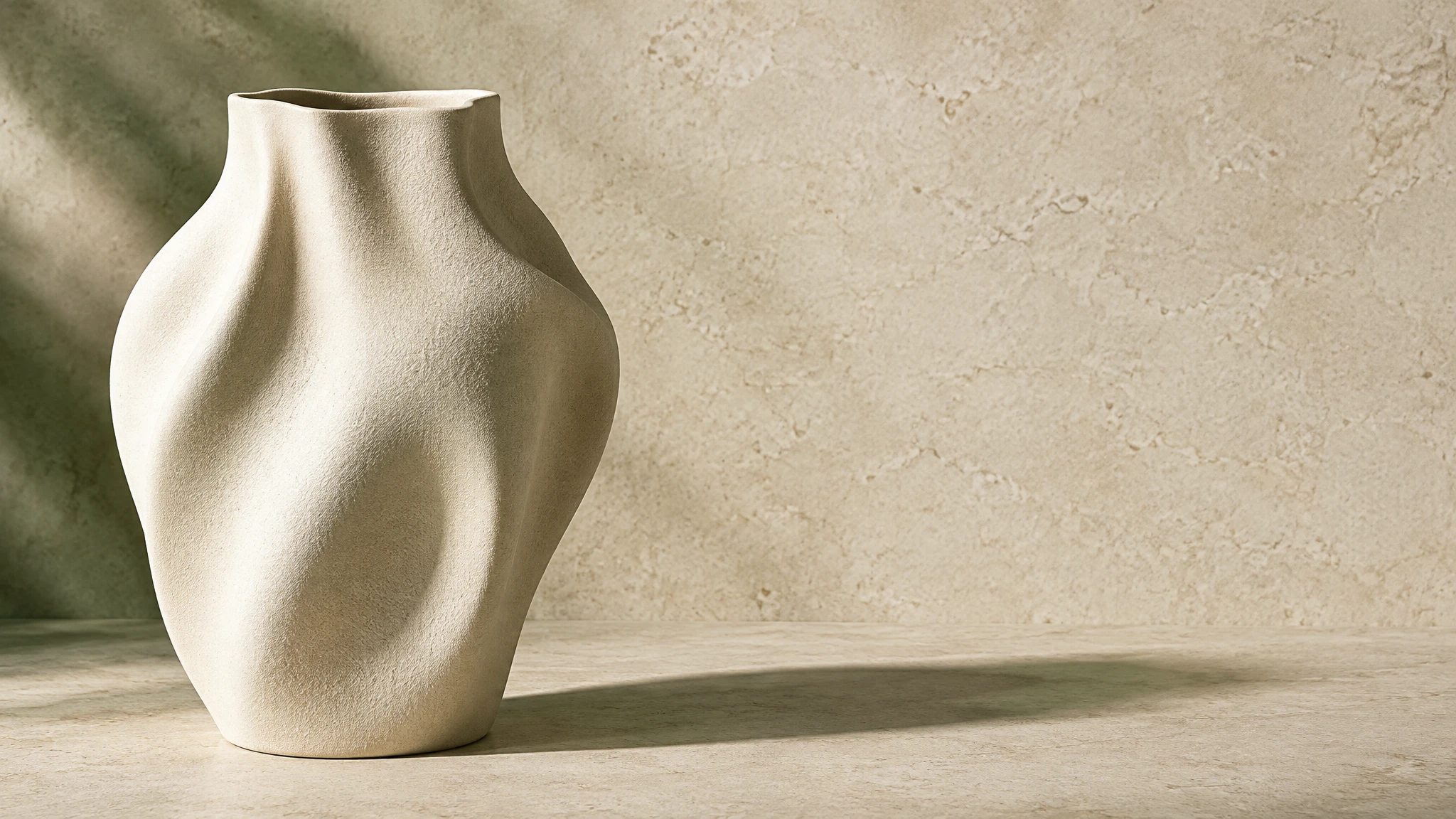 Pale sculptural ceramic vase on a warm stone backdrop